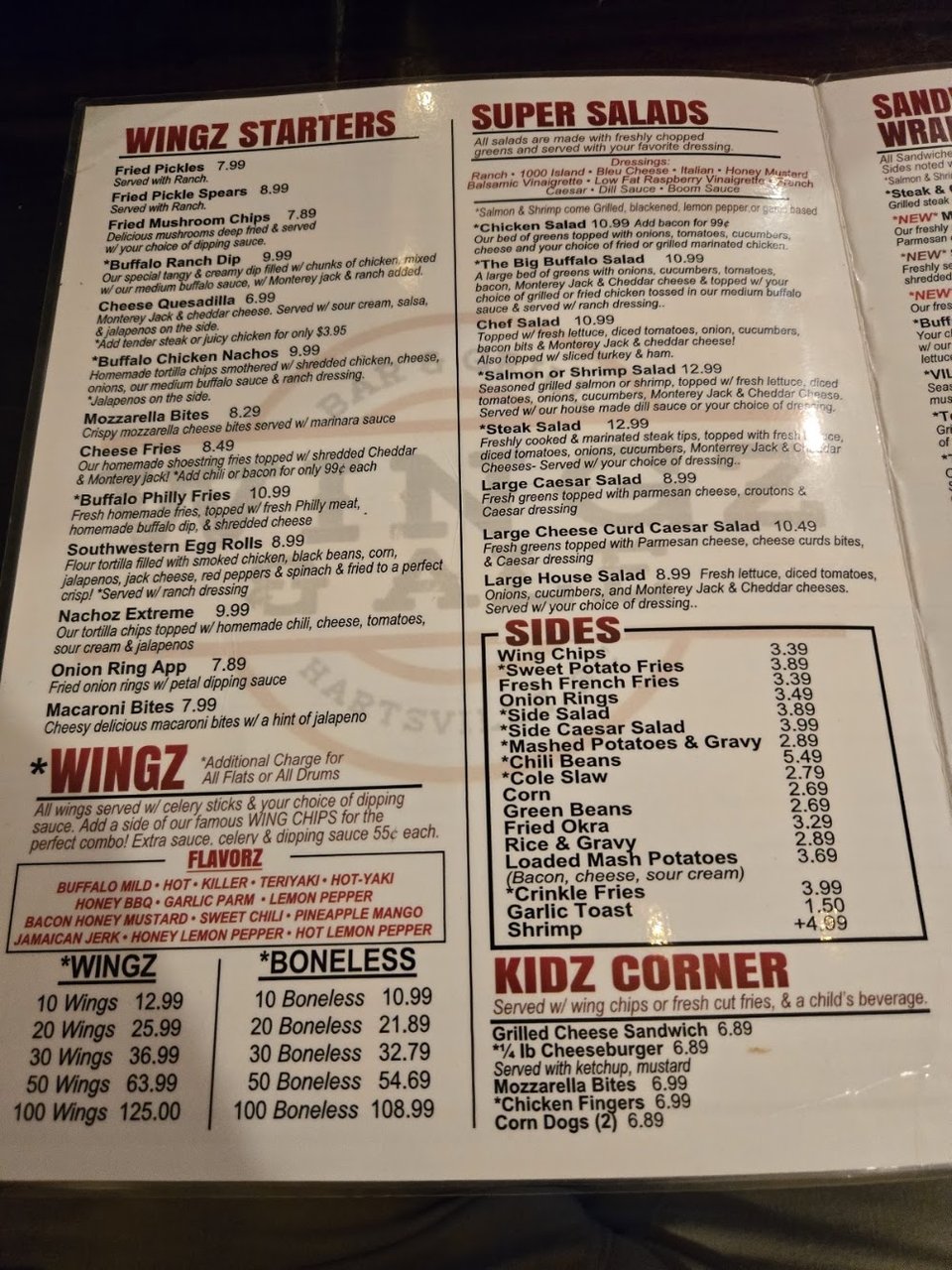 Printed menu with wings, salads, and sandwiches.